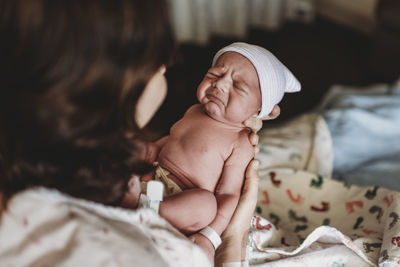 Newborn boy with hat in hospital making funny face