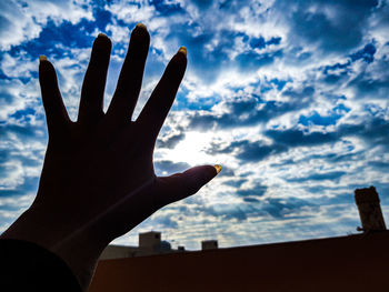 Low angle view of silhouette hand against sky during sunset