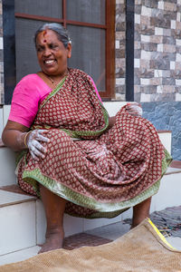 Portrait of a smiling young woman sitting on seat