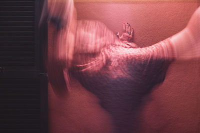 Close-up of human hand on pink wall