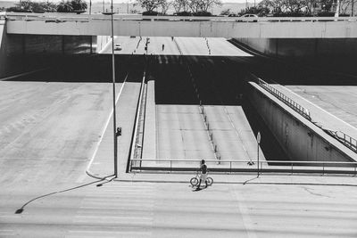 Man with bicycle walking on road in city