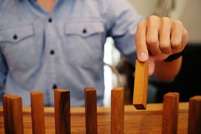 Close-up of man playing dominoes on table