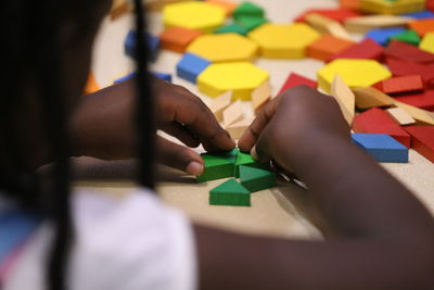 Close-up midsection girl playing with toy blocks on table