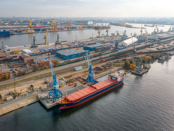 Aerial photo of port with boat, cranes and buildings. port cranes load various cargoes into the hold