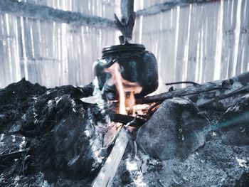 Side view of young man smoking on log