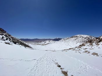 Scenic view of snowcapped mountains against clear blue sky