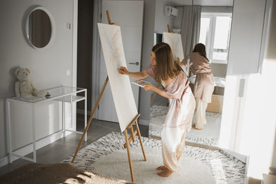 Portrait of smiling young woman standing at home