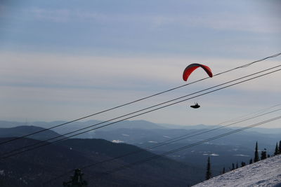 Low angle view of paragliding against sky