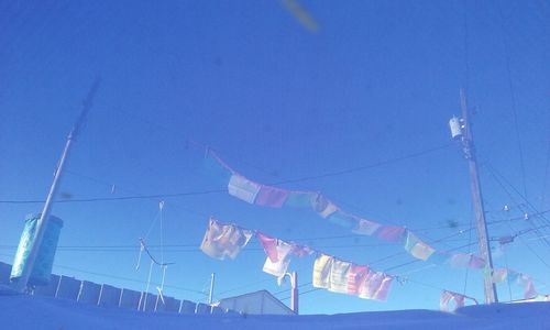 Low angle view of cables against clear blue sky