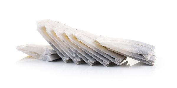 Close-up of tea bags against white background