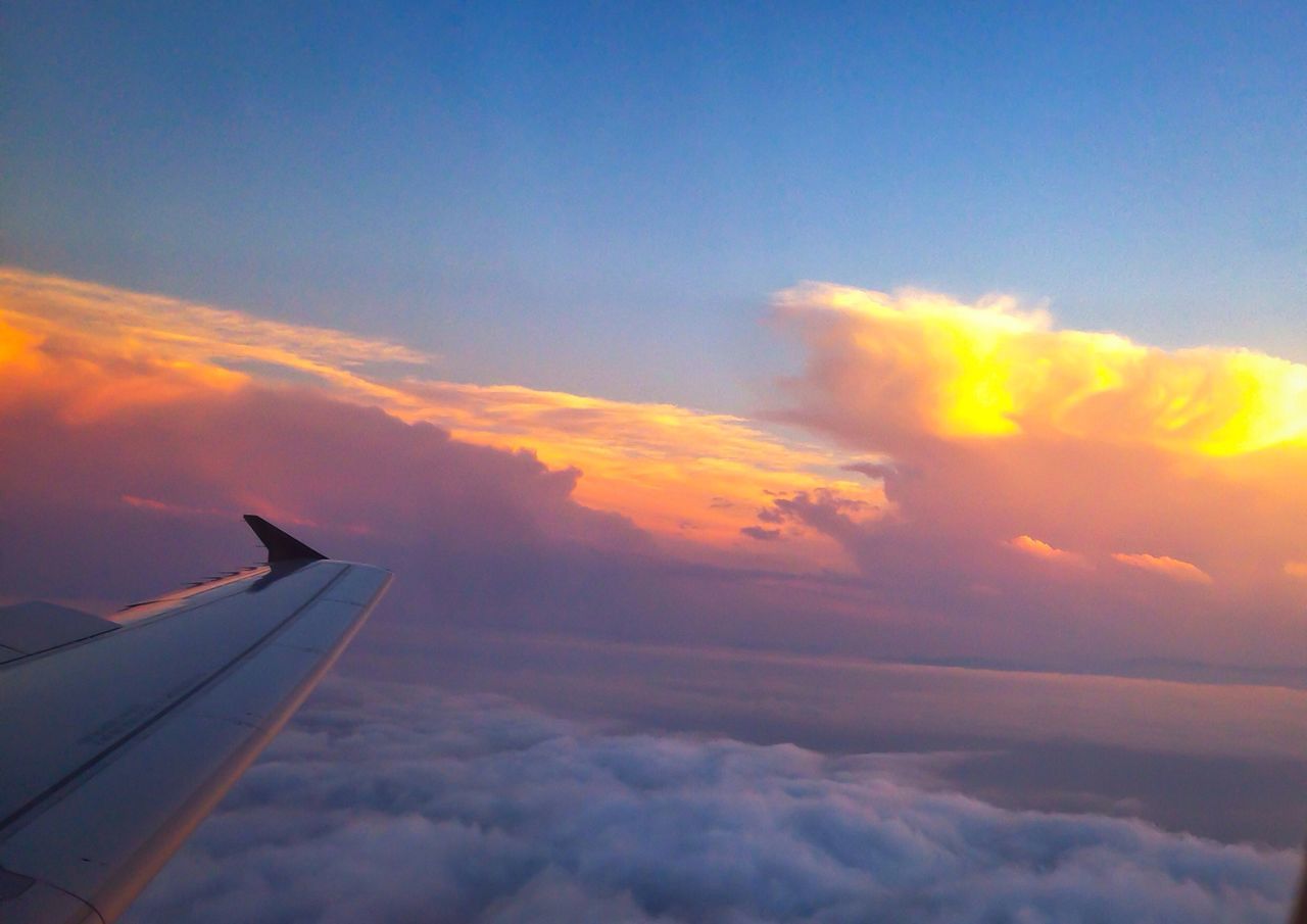 airplane, flying, sky, low angle view, sunset, air vehicle, cloud - sky, mid-air, transportation, aircraft wing, cloud, part of, nature, mode of transport, orange color, beauty in nature, sun, cloudscape, outdoors, no people