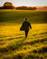 Rear view of woman standing on field