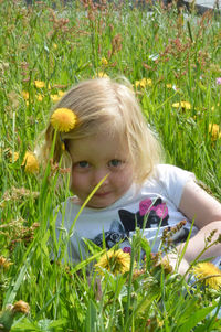 Portrait of cute girl lying on grassy field