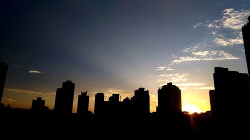 Silhouette buildings against sky during sunset