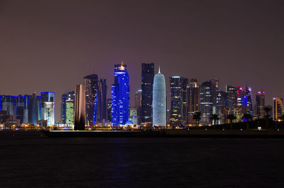 Illuminated doha tower and buildings in city