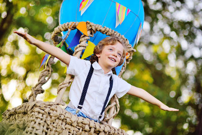 Smiling boy standing in hot air balloon