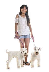 Portrait of woman with dog standing against white background