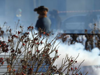 Man and woman standing by plants against sky