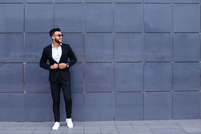 Portrait of businessman standing against wall