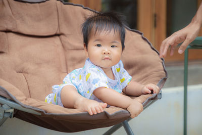 Full length of cute baby sitting at home