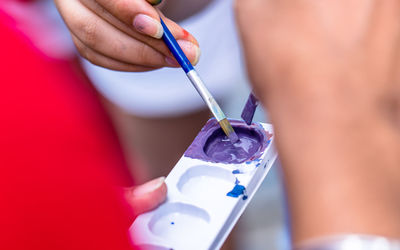 Cropped hand of woman painting