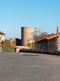 Road by building against clear sky