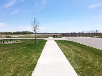 Footpath in park against sky