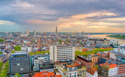 High angle view of buildings in city against cloudy sky