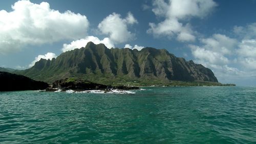 Scenic view of sea and mountains against sky