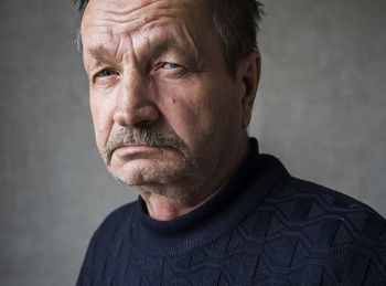 Portrait of senior man against gray background