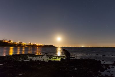 Scenic view of lake against sky at night