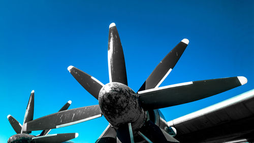 Low angle view of propeller of planes clear blue sky