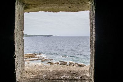 Scenic view of sea against sky seen through window