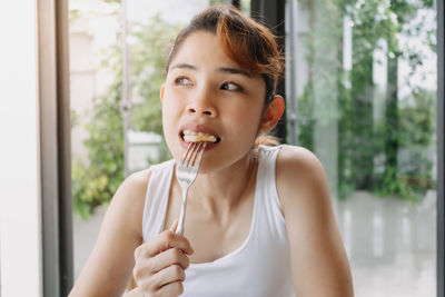 Beautiful woman eating food at home