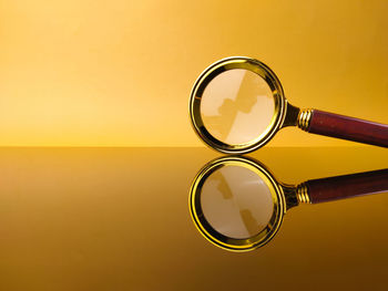 Close-up of magnifying glass against blue background