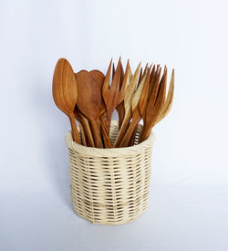 Close-up of wicker basket on table against white background