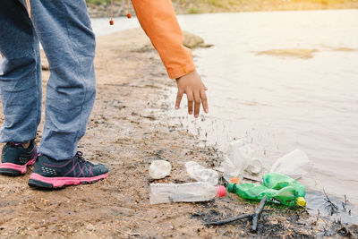 Volunteer cleaning lakeshore at forest