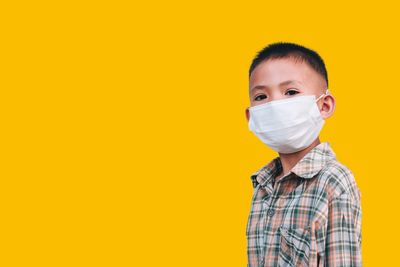 Portrait of boy against yellow background