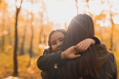 Mother and daughter at park during autumn