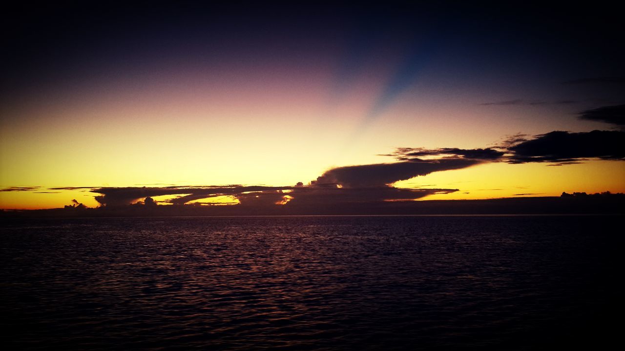 sunset, water, silhouette, scenics, tranquil scene, sea, beauty in nature, tranquility, sky, orange color, waterfront, sun, nature, idyllic, rippled, copy space, horizon over water, reflection, outdoors, sunlight