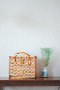 Wicker basket on table against wall at home