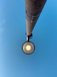 Low angle view of security camera against clear blue sky