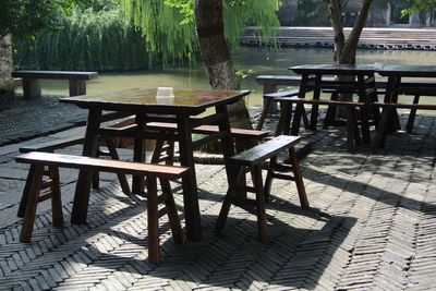 Empty table and chairs by trees