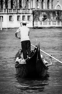 Rear view of man rowing gondola at grand canal