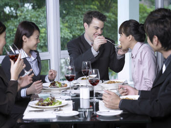 Colleagues with drinks at restaurant during meeting