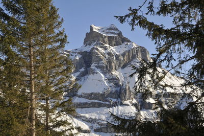 Low angle view of snowcapped mountain against clear sky