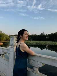 Women standing by railing against sky