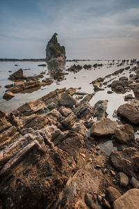 Rocks on beach against sky