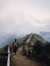 Rear view of woman looking at mountain against sky