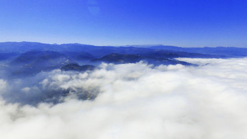 Scenic view of mountains against blue sky